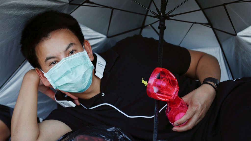 Un hombre se enfría con un ventilador portátil mientras los deudos esperan la ceremonia de la Cremación Real del rey Bhumibol Adulyadej de Tailandia en el Gran Palacio en Bangkok, Tailandia