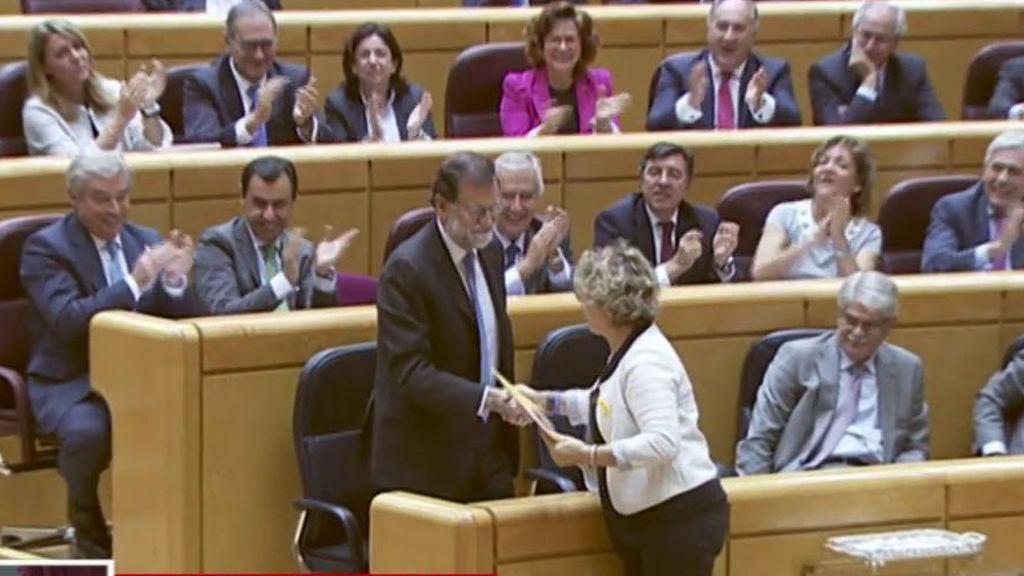La senadora de ERC le entrega un libro a Mariano Rajoy y este le da un ejemplar de la Constitución