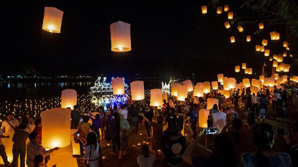 Un grupo de personas lanza linternas flotantes durante el Festival de Yee Peng