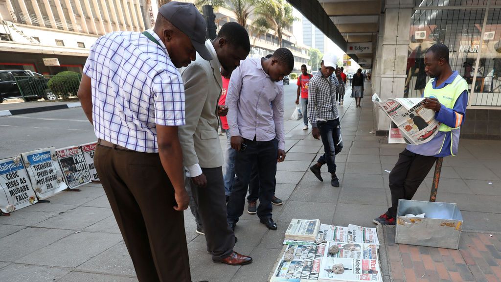 Los zimbabuenses leen los titulares de los periódicos después de la renuncia del presidente Robert Mugabe en Harare, Zimbabwe
