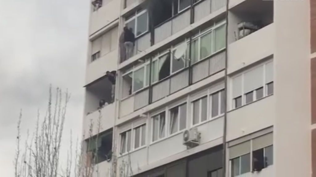 Colgados de la fachada por un aparatoso incendio en el que ha muerto una mujer de 35 años