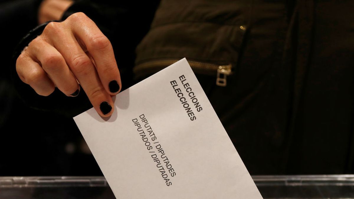 Una mujer presenta su voto en las elecciones regionales de Cataluña en un colegio electoral