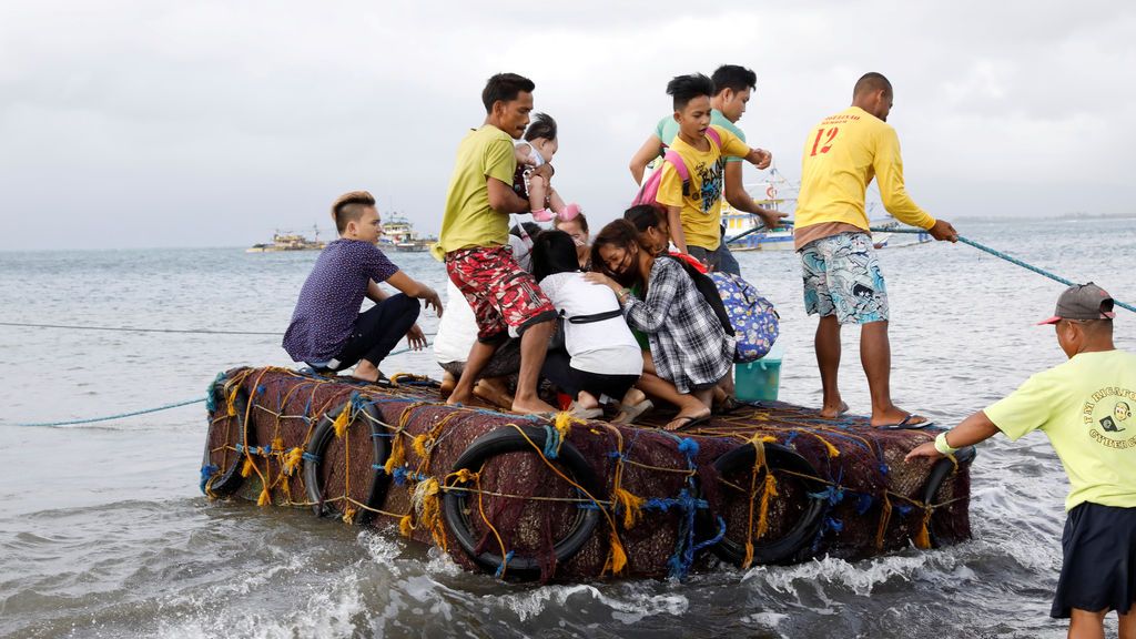 Los pasajeros varados viajan en una balsa improvisada después de que se cancelaron todos los servicios del ferry, un día después de que un buque filipino zozobró debido al mal tiempo en Infanta, Quezon en Filipinas