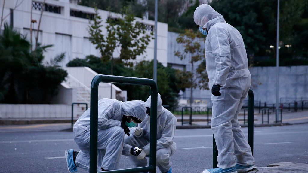 Los agentes de policía buscan evidencia después de la explosión de una bomba en un edificio del Tribunal en Atenas, Grecia