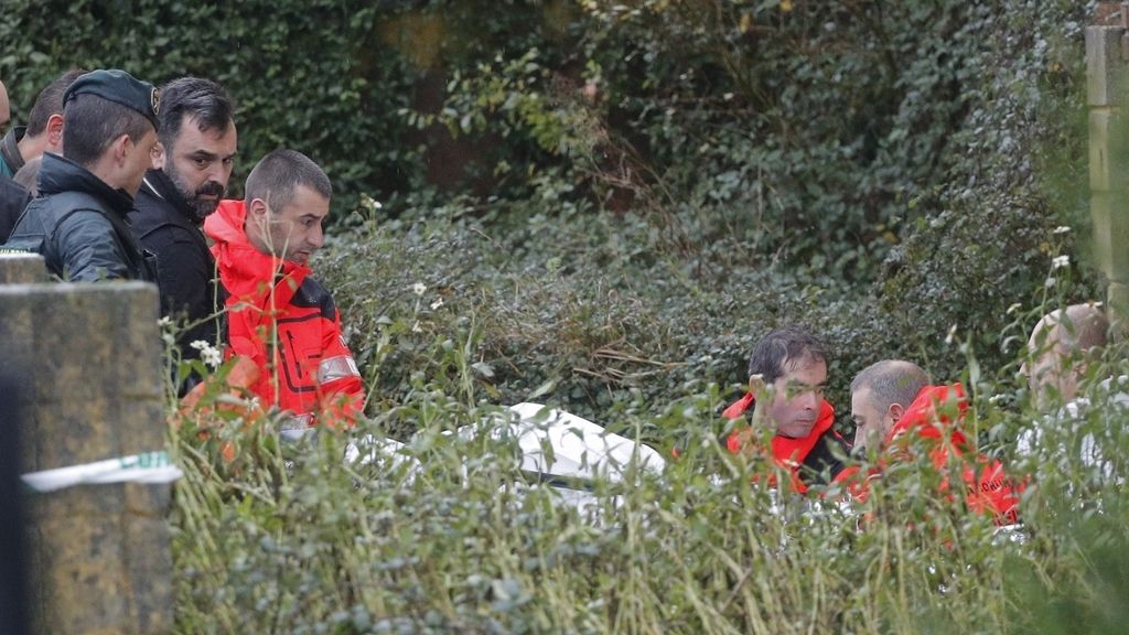 Efectivos de la Guardia Civil y bomberos trasladan en una camilla los restos del supuesto cadáver de Diana Quer