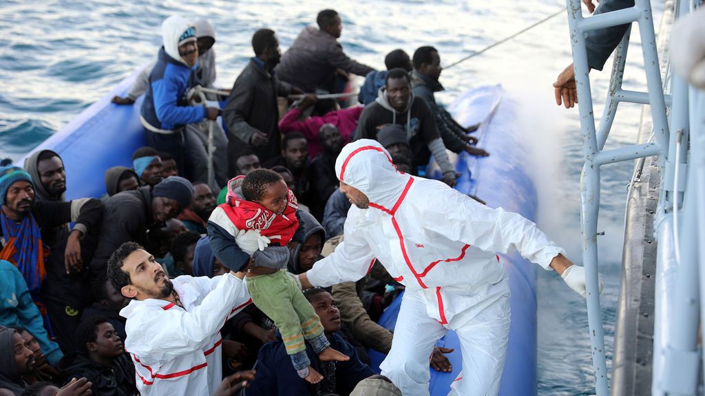 Un niño migratorio es llevado mientras otros socorristas en un lúgubre son rescatados por guardias costeros libios frente a la costa de Garabulli, al este de Trípoli, Libia