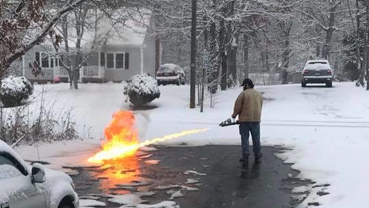 Un estadounidense usa un lanzallamas para quitar la nieve de la carretera