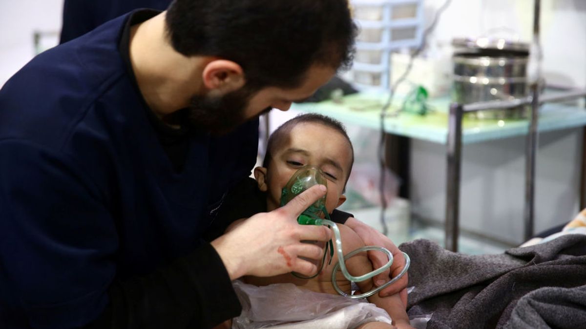 Un hombre asiste a un bebé en un centro médico en Douma, Ghouta Oriental, Damasco, Siria