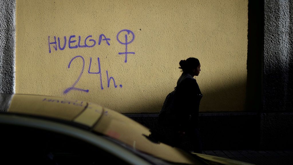 Una mujer pasa frente a un graffiti de la huelga feminista del 8 de marzo en Bilbao