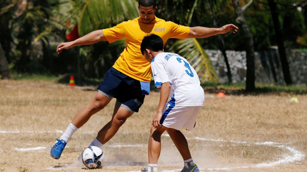 Un marinero estadounidense juega al fútbol con un niño durante su visita a la Aldea Infantil SOS Da Nang en Vietnam