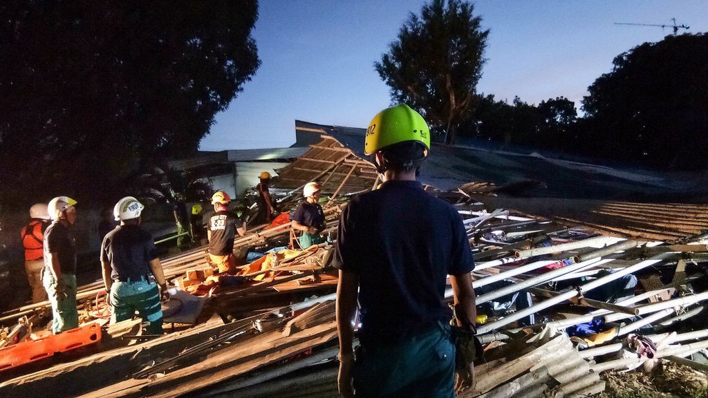 Personal de rescate ayuda a los heridos después de que un edificio de viviendas se derrumbara en Cebu, (Filipinas)