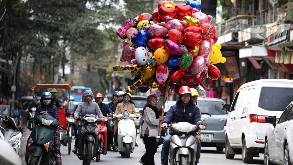Varias mujeres venden globos en una calle de Hanói (Vietnam)