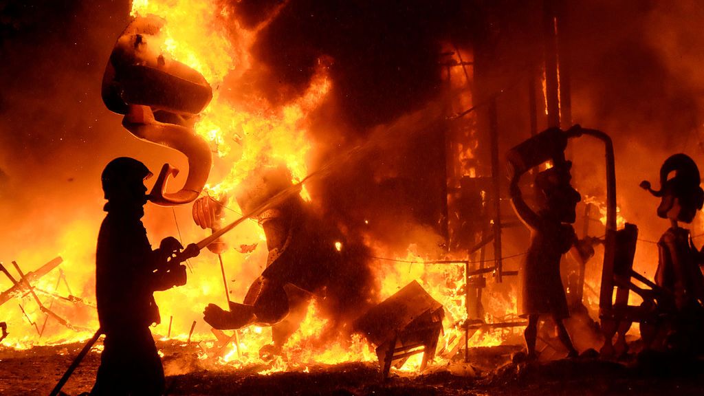 Un bombero apaga el fuego de las figuras de una falla durante el final de las Fallas, que da la bienvenida a la primavera, en Valencia