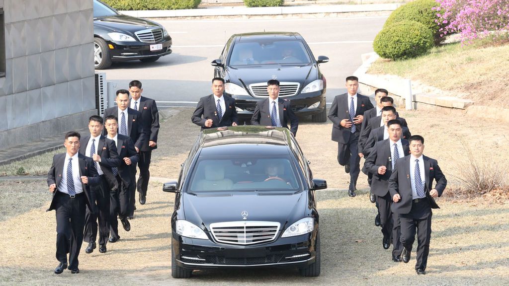 Trece guardaespaldas a pie siguen el coche de Kim Jong-un en Corea