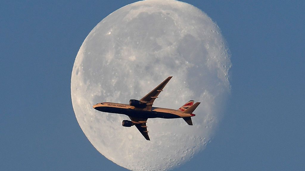 Impresionante fotografía el vuelo de un avión frente a la luna