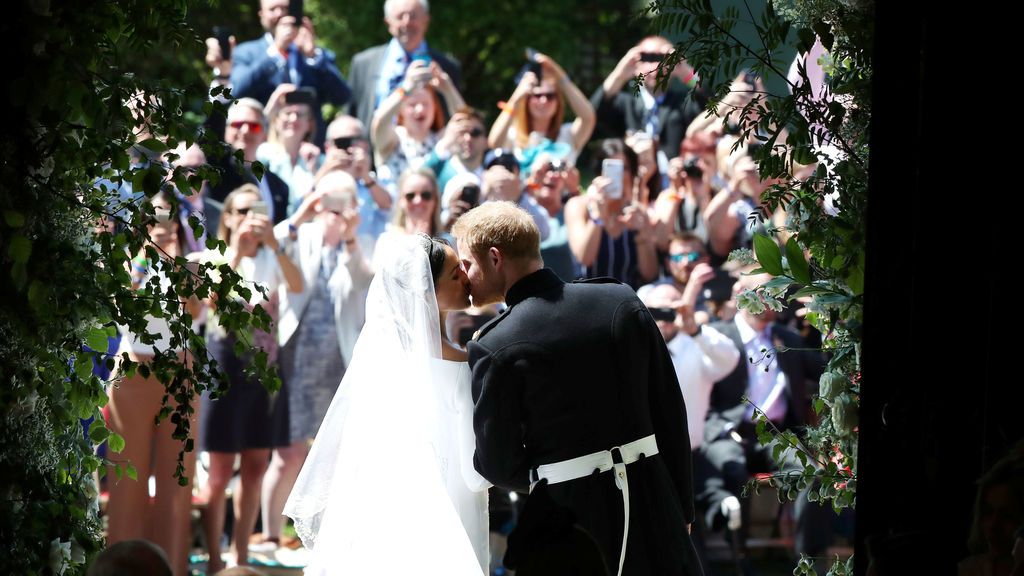 El matrimonio se besa ante las personas que les esperaban a la salida de la capilla de San Jorge