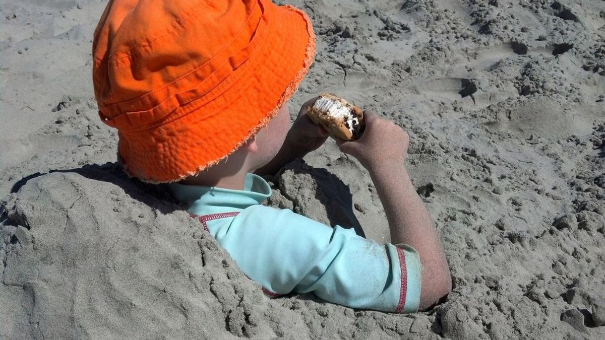 Niño comiendo en la playa