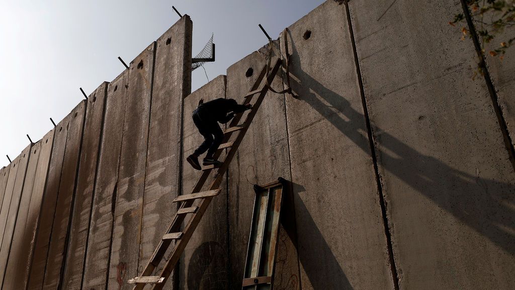 Un palestino cruza el muro para llegar a la oración