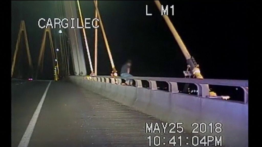 Agentes de policía rescatan a una mujer al borde de un puente