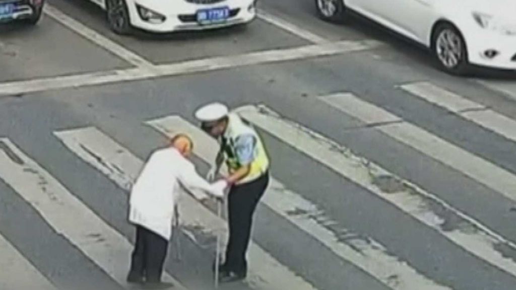 La peculiar forma en que un policía ayuda a un anciano a cruzar la carretera