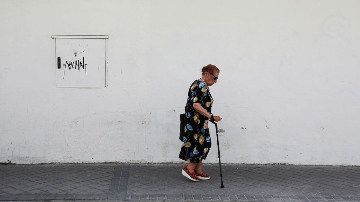 Un mujer mayor camina por una calle de Madrid