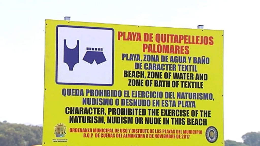 Un cartel separa a los nudistas y a los bañistas con ropa en la playa de Quitapellejos