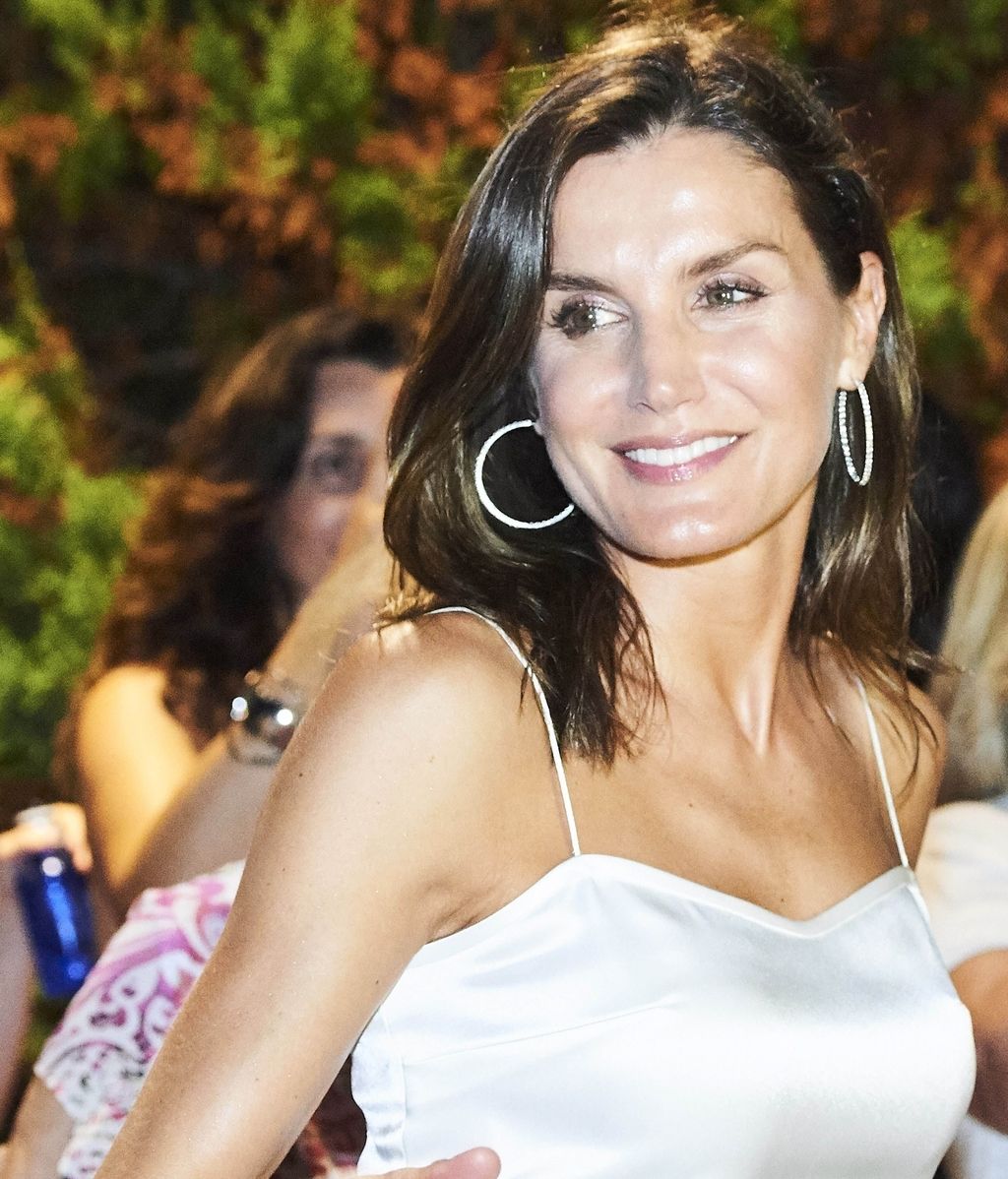 Letizia, sonriente, acompañaba su look con unos grandes aros, y un maquillaje natural