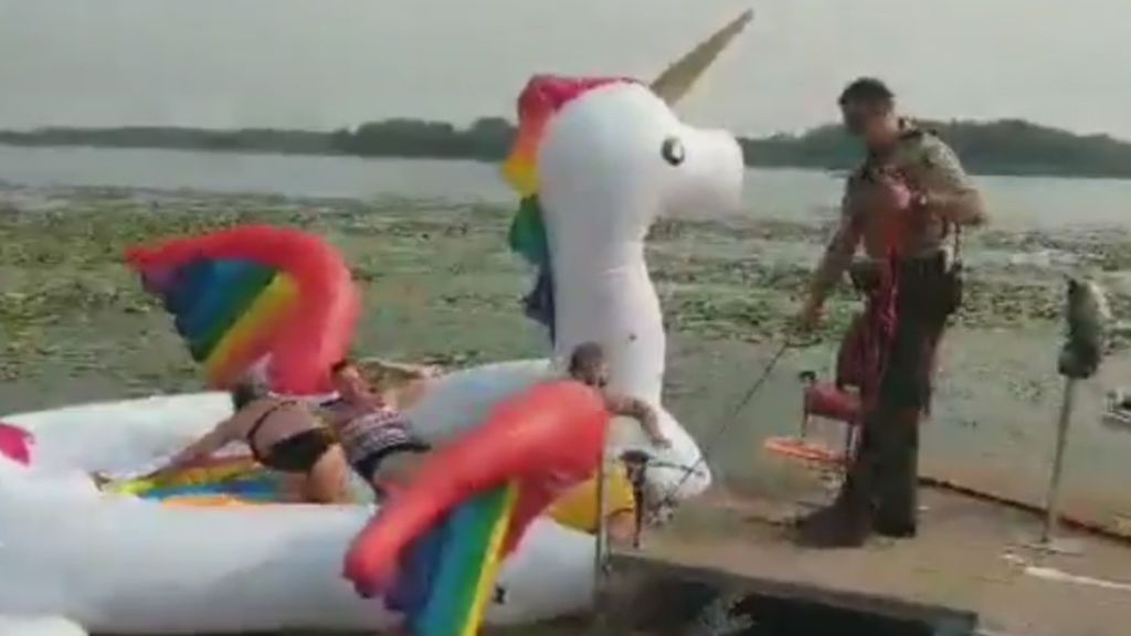 Rescatan a un grupo de personas a la deriva en un flotador unicornio en un lago