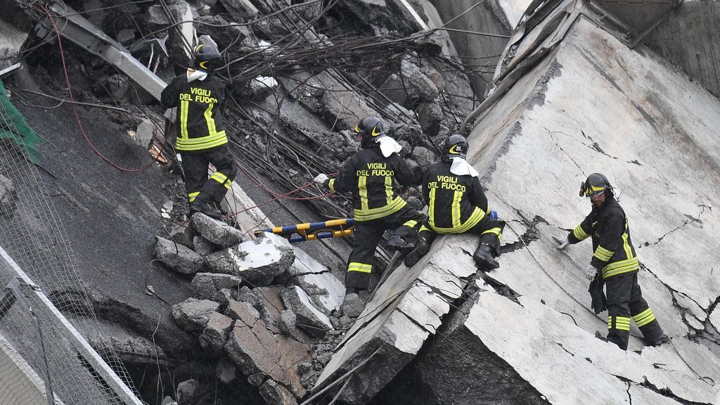 Varios miembros de los equipos de rescate rastrean los escombros