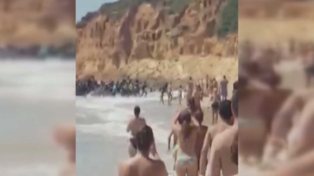 Veraneantes frente a inmigrantes: Medio centenar de inmigrantes desembarca en una playa de Cádiz