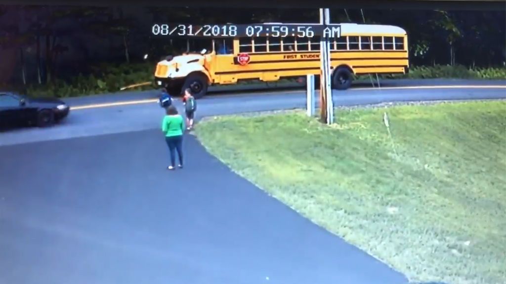 Un niño está a punto de ser atropellado cuando intenta subirse al autobús escolar
