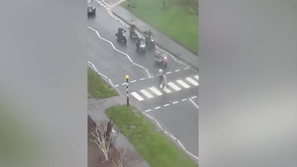 Se baja de su moto para ayudar a una anciana a cruzar un paso de cebra