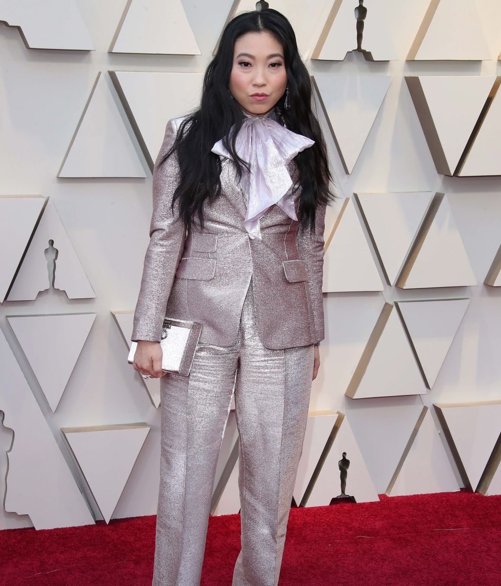 Awkwafina vestida con un esmoquin plateado
