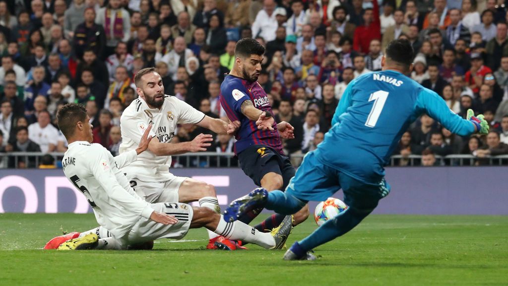 Varane intenta evitar el gol de Luis Suárez en el Clásico.