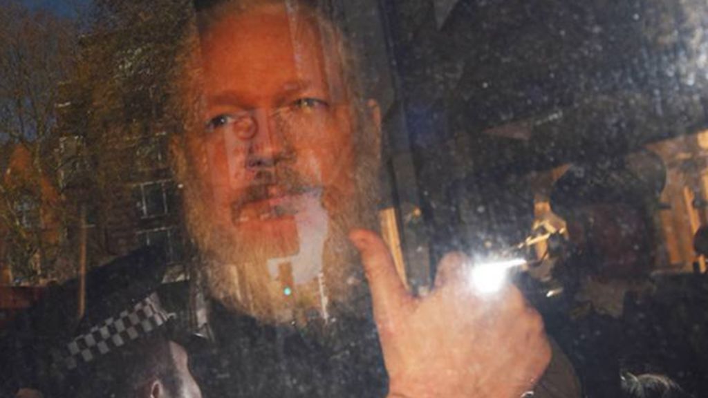 La nueva imagen del detenido Assange: Esposado, con barba y muy envejecido.