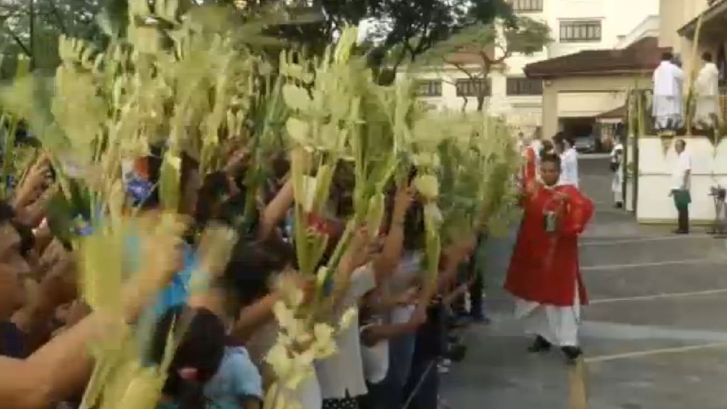 Los filipinos acuden con la tradicional palma a la misa del Domingo de Ramos