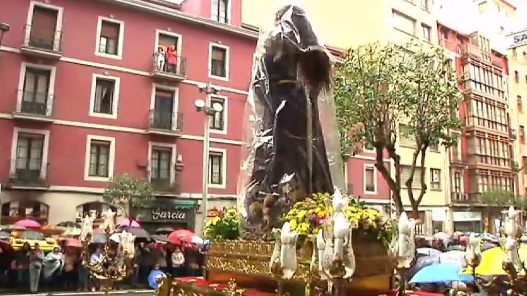 El nazareno se pone el chubasquero para recorrer las calles de Bilbao