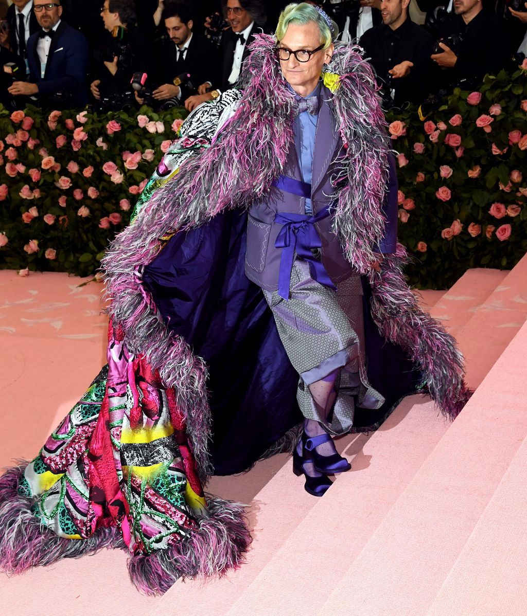 Hamish Bowles con capa de plumas, kimono, chaqueta y merceditas