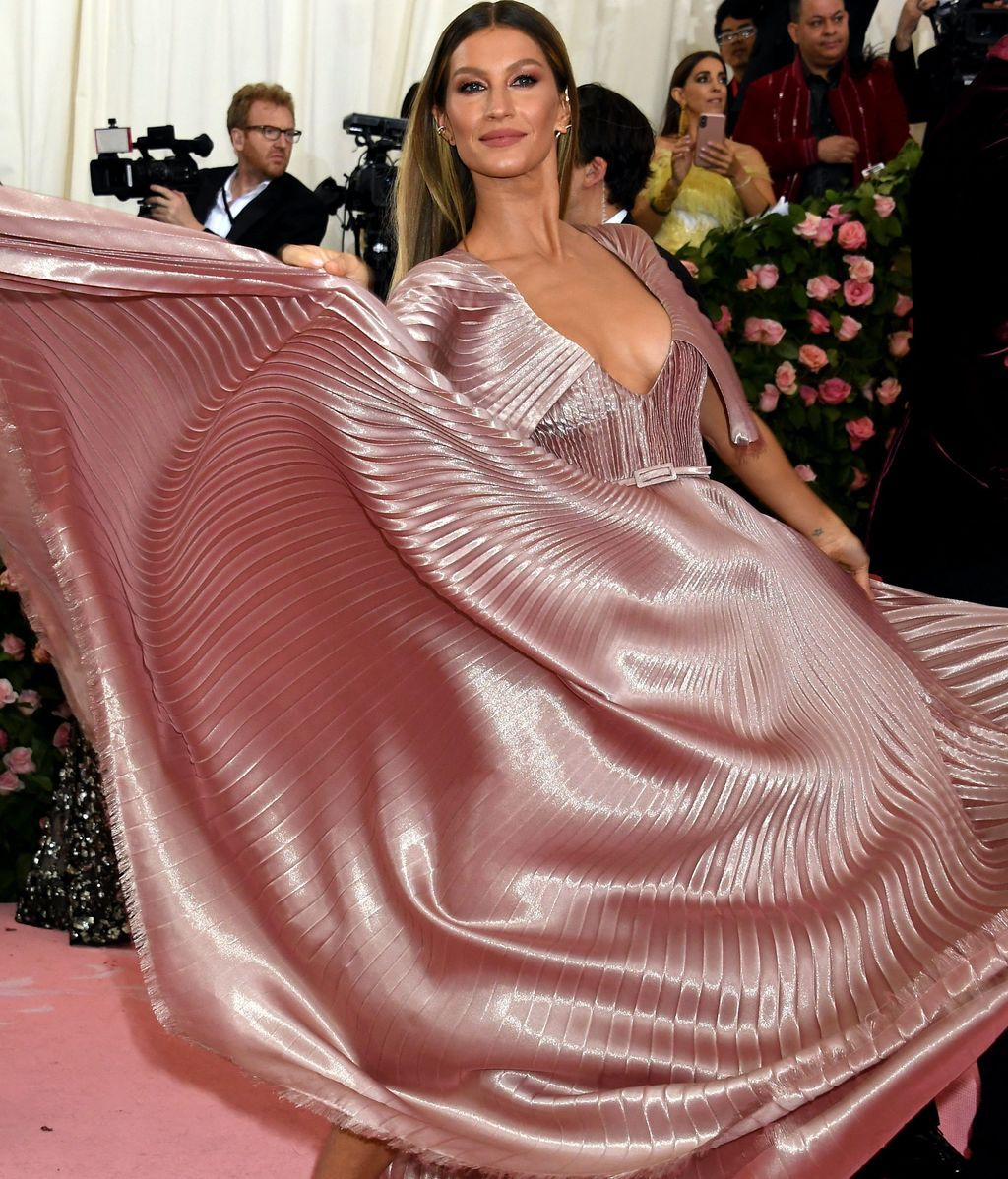 Gisele Bundchen con vestido plisado, metalizado en tonos empolvados