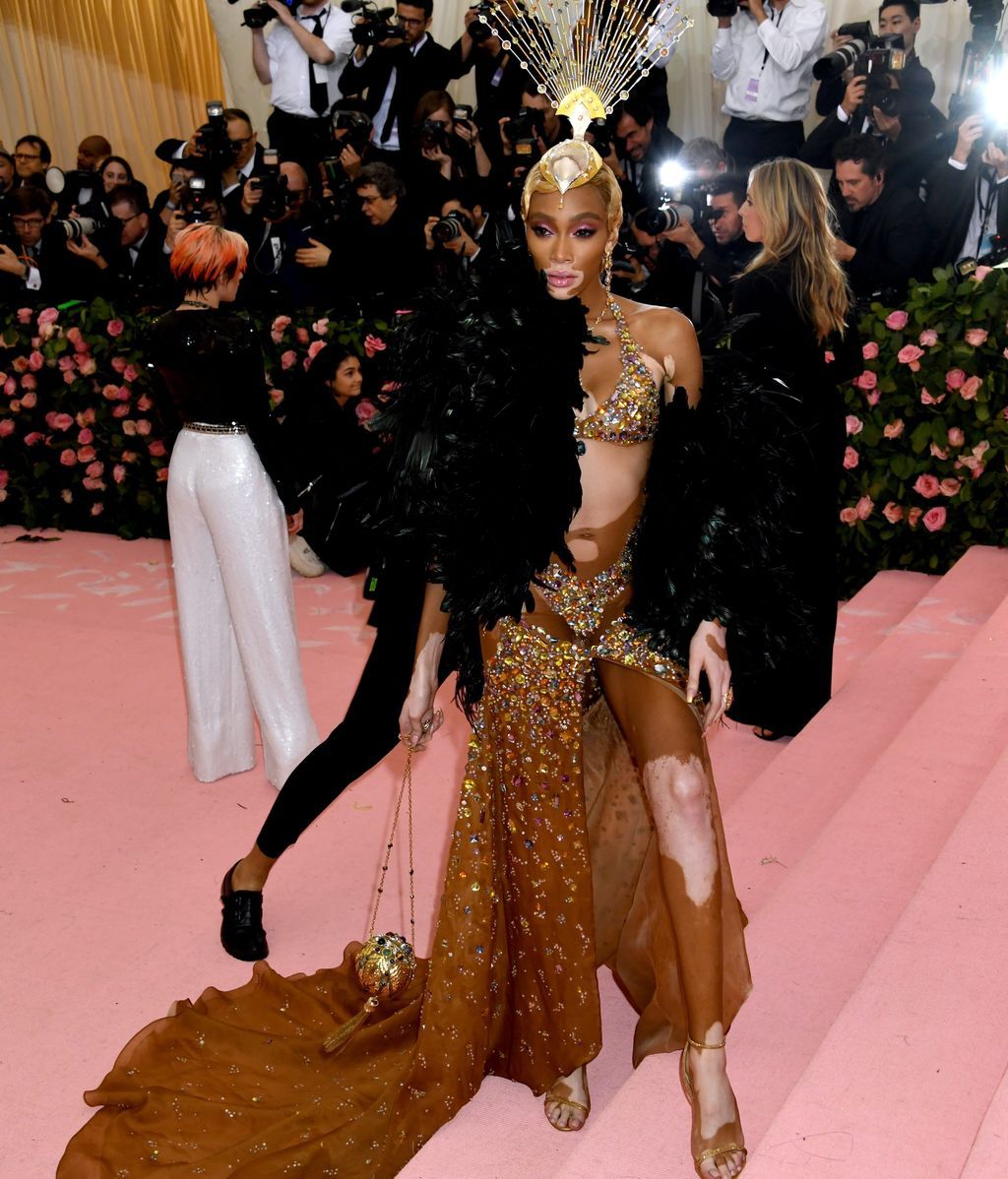 Winnie Harlow con vestido de cristales y boa de plumas
