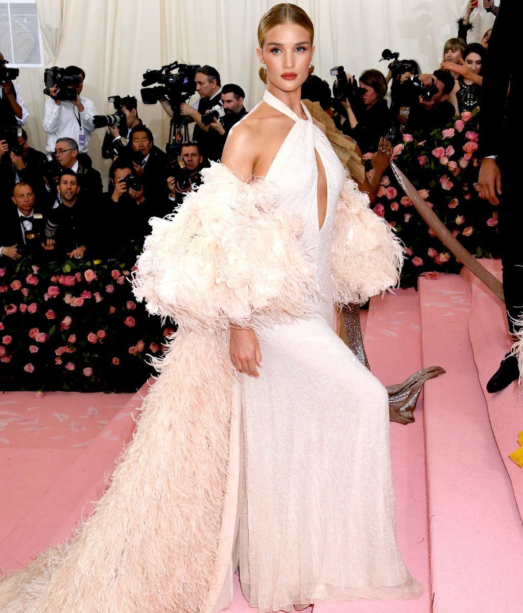 Rosie Huntington-Whiteley con vestido blanco y capa de plumas de Oscar de la Renta