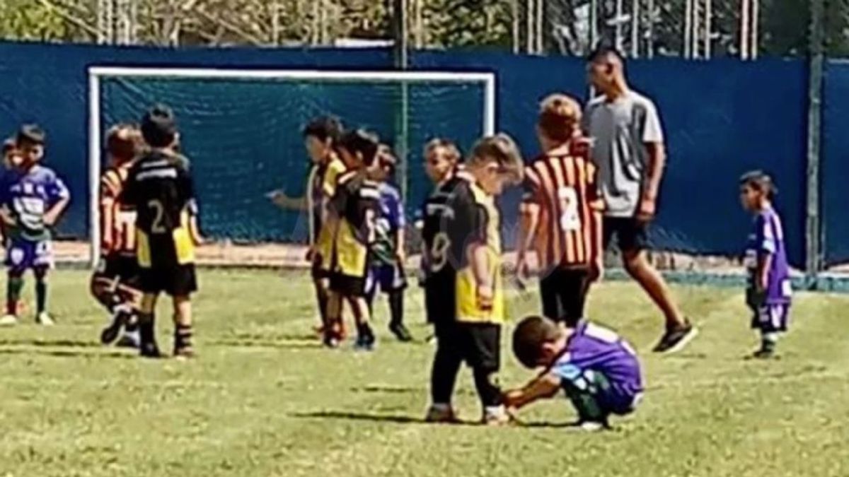 Un niño da una lección de deportividad al agacharse para atarle los cordones a un jugador del equipo rival