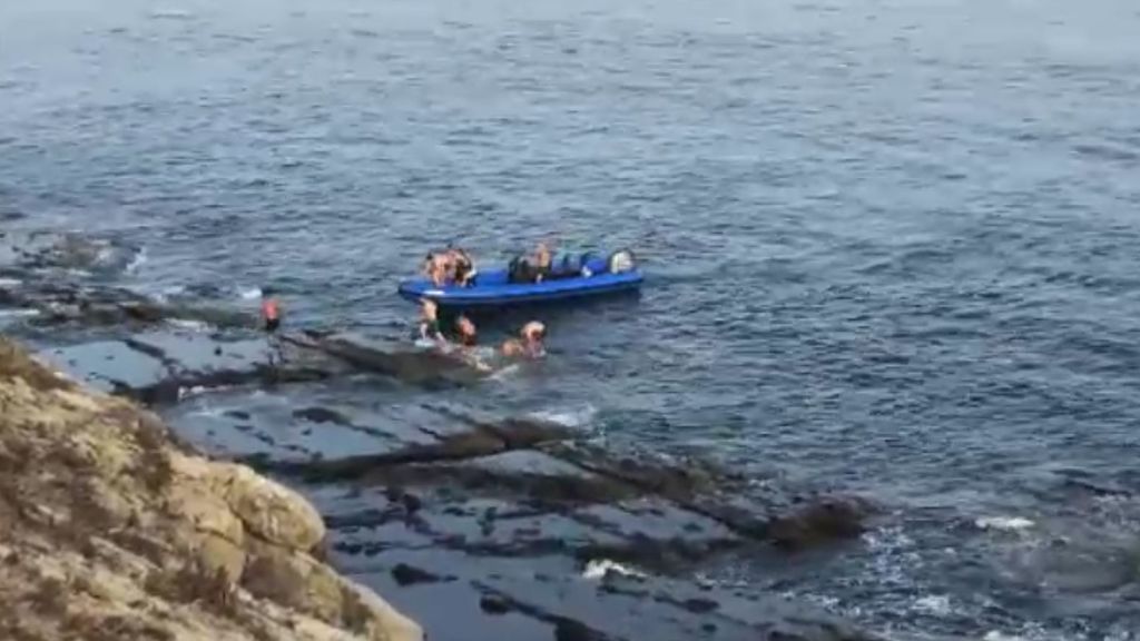 Una lancha deposita a un grupo de inmigrantes cerca de la orilla en Tarifa
