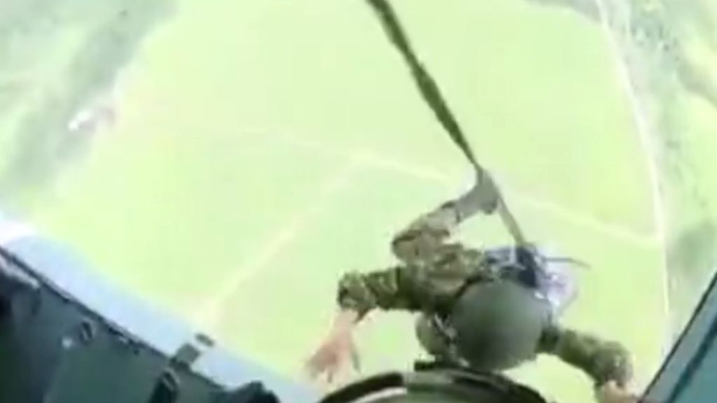 Un instructor militar empuja a un paracaidista paralizado por el miedo