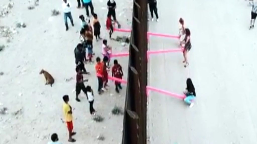 Una imagen para la reflexión: niños jugando a uno y otro lado de un balancín en la valla que separa México y EEUU