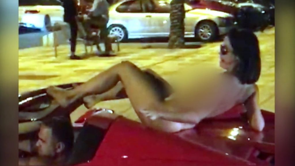 Un hombre pasea por Ibiza con un Ferrari y una mujer desnuda sobre el coche