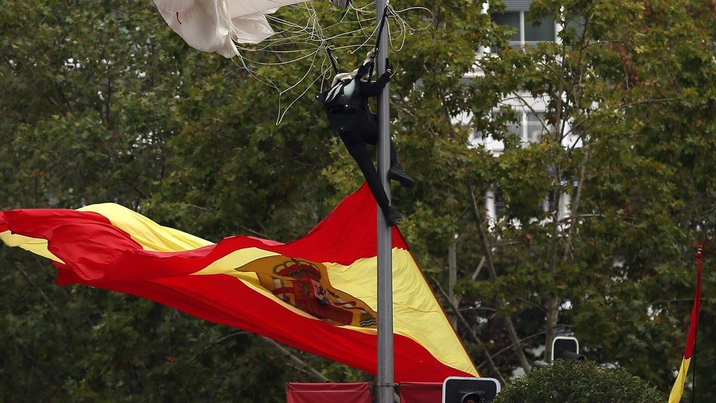 Desfile del Día de la Hispanidad: El paracaidista que lleva la bandera se engancha a una farola