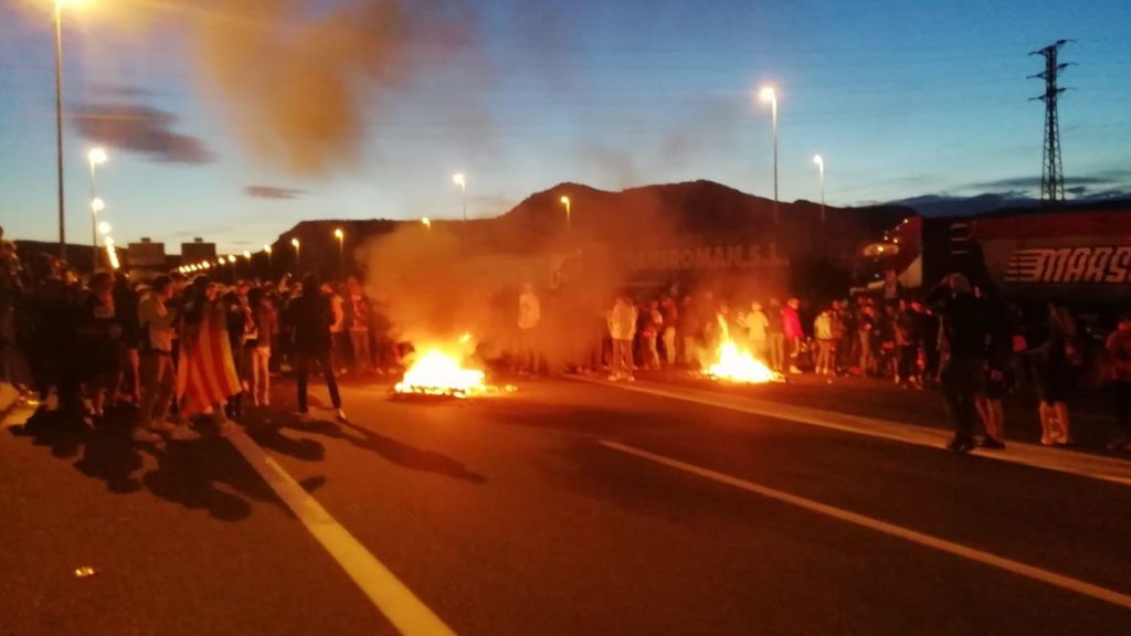 Manifestantes quemando palets en al C17