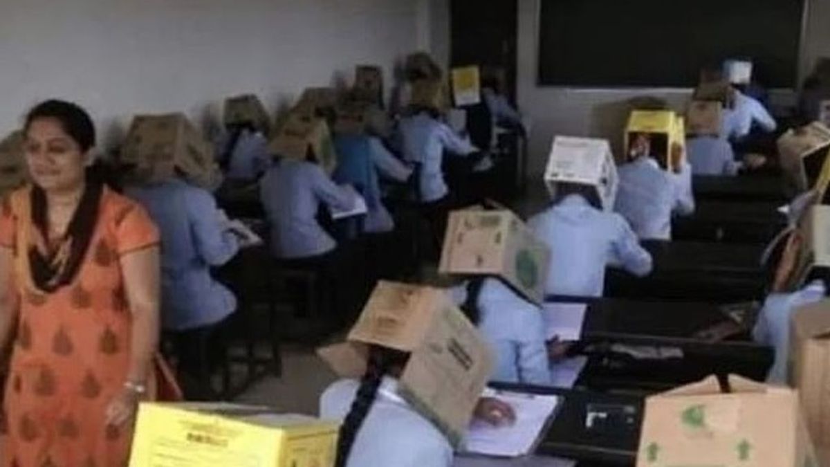 Una escuela india examina a sus alumnos con una caja de cartón en la cabeza para evitar que copien