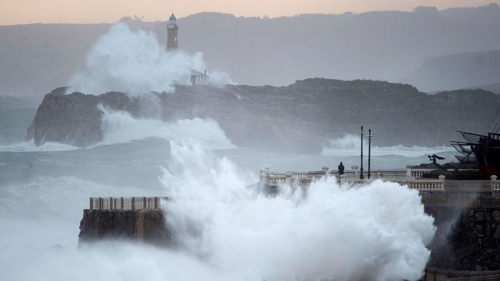 Una ola rompe en el faro de la isla de Mouro